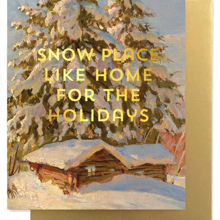 Greeting card with snowy landscape and cabin, featuring yellow text saying, 'Snow place like home for the holidays'. A gold foil envelope is included.
