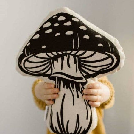 White and black pillow in the image of a mushroom.