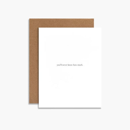 White card with black text saying, “You’ll never know how much”. A brown kraft envelope is included.