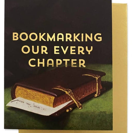 Card with classical painting of a vintage leather book and yellow text saying, “BOOKMARKING OUR EVERY CHAPTER”. A gold foil envelope is included.