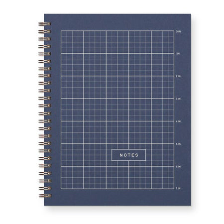 Blue notebook with grid pattern and 'NOTES' label on a white background. Gold coil binding on left side.