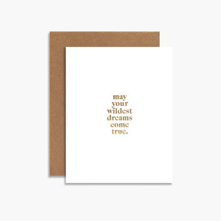 White card with gold foil text saying, “May your wildest dreams come true”. A brown kraft envelope is included.