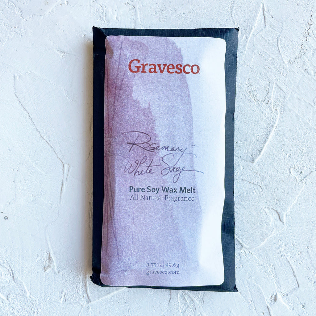 Packaged in a black rectangle pouch with white and gray label with black and red text saying, “Gravesco Rosemary White Sage Wax Melt”.