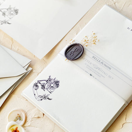 Stationery set with ivory paper and black ink. Image of a vintage rotary phone with flowers. Matching envelopes included.