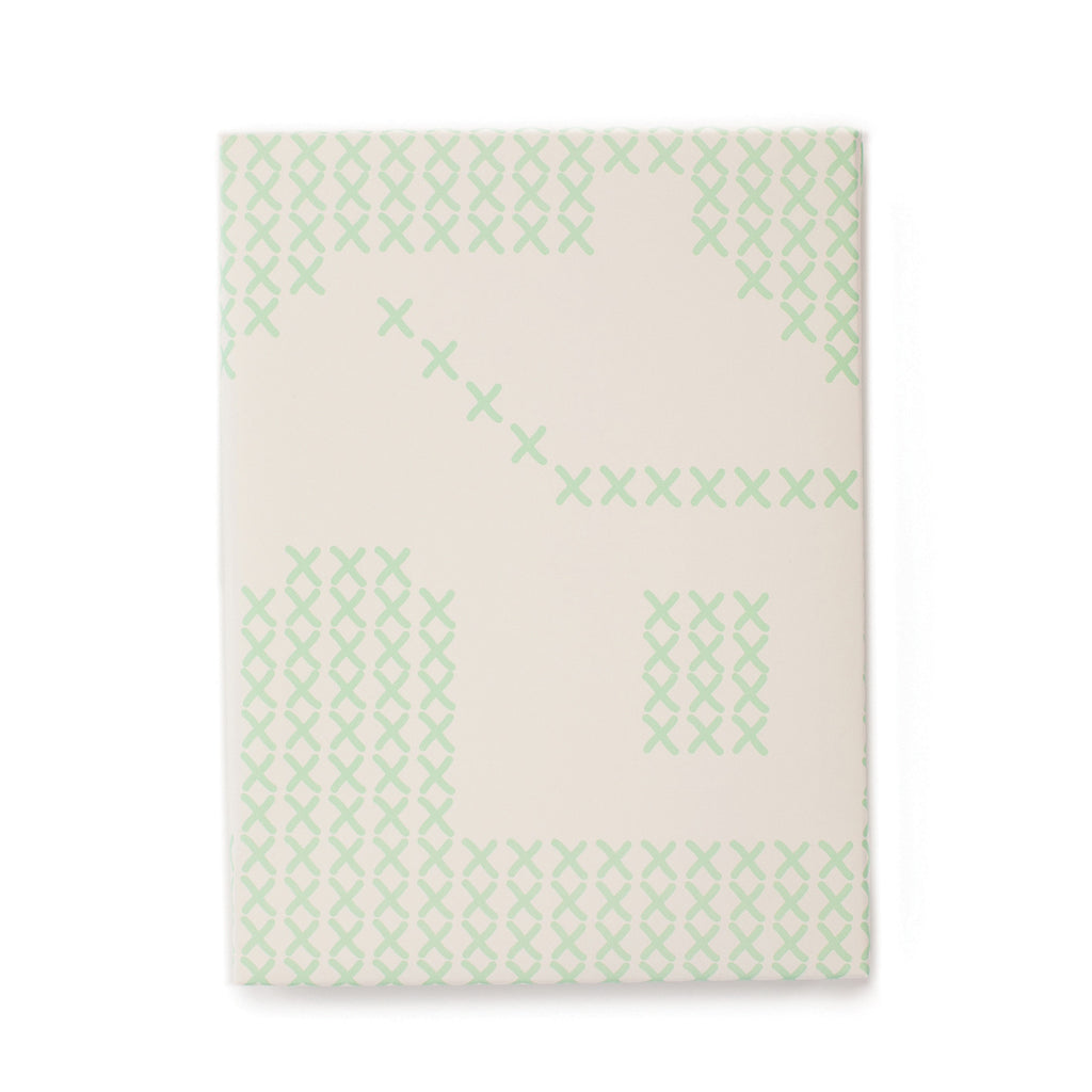 Ivory background with images of green x stitching pattern across paper showing a house.