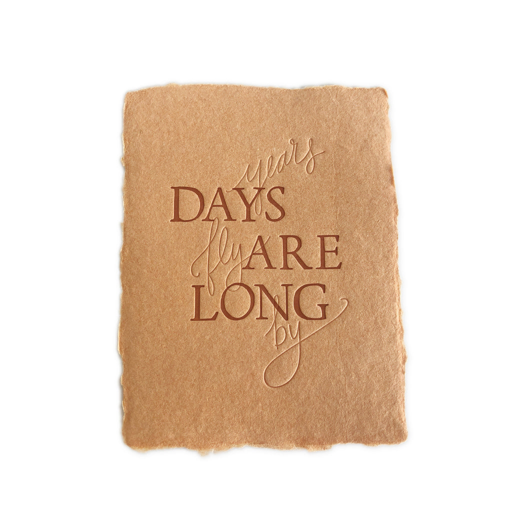 Brown kraft paper card with brown and embossed text saying, “Days Are Long Years Fly By”. An envelope is included.