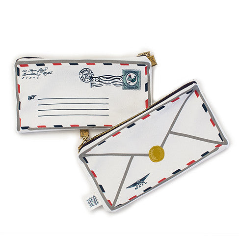 Double sided pencil pouch in the image of a classic parcel post mailing envelope. Front side has return address script; blue lines for the sending address; and a blue stamp in top right corner. Back side looks like the back flap of an envelope with a gold seal circle in the center. Gold metal zipper.