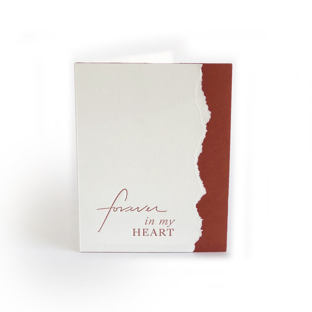 White and red card with curved vertical line where colors meet. Red text saying, “Forever in My Heart”. A white envelope is included.