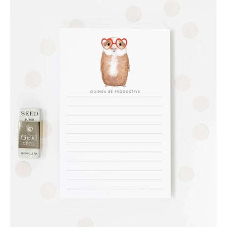 White notepad with image of a brown guinea pig wearing red heart glasses. Black text saying, 