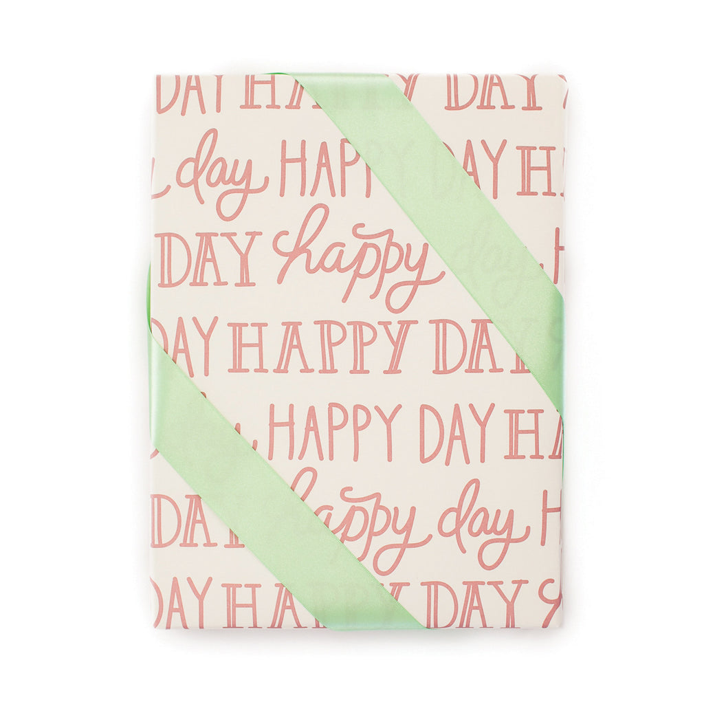 Ivory background with red text saying, “Happy Day” tiled on paper.
