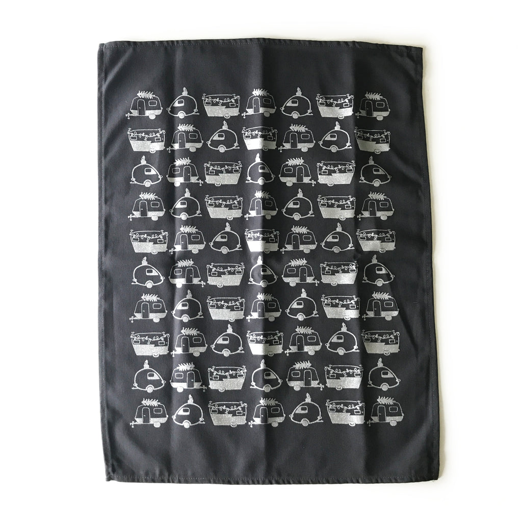 Black tea towel with images of white vintage campers tiled across towel.