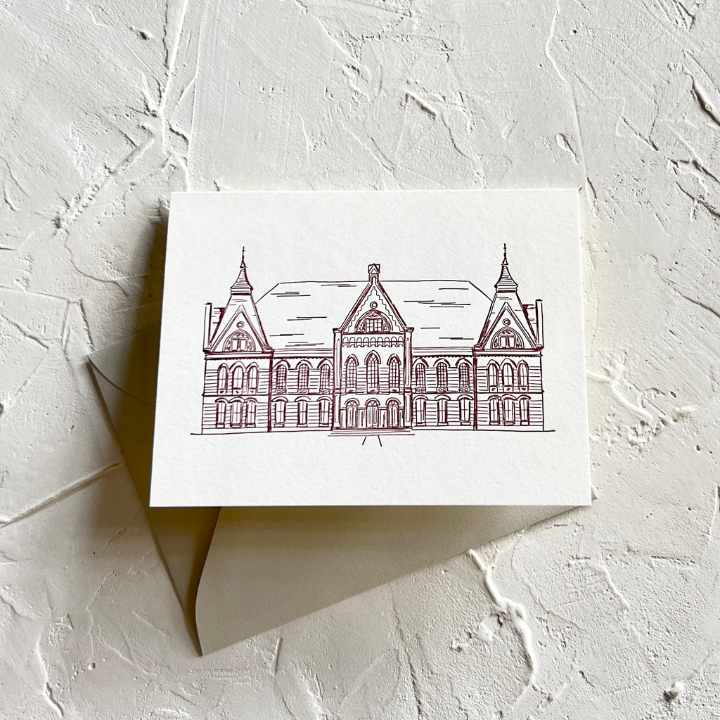 Ivory background with burgundy ink with image of a large mansion from Texas State University. A gray envelope is included.