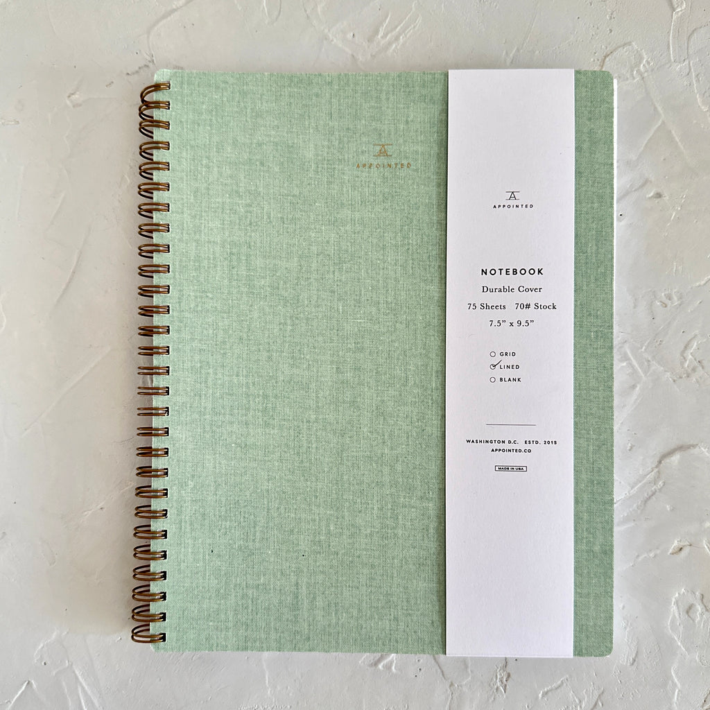 Mint green textured cover with brass spiral on left side.