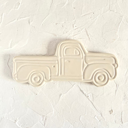 Ivory ceramic with embossed image of a vintage pick up truck.