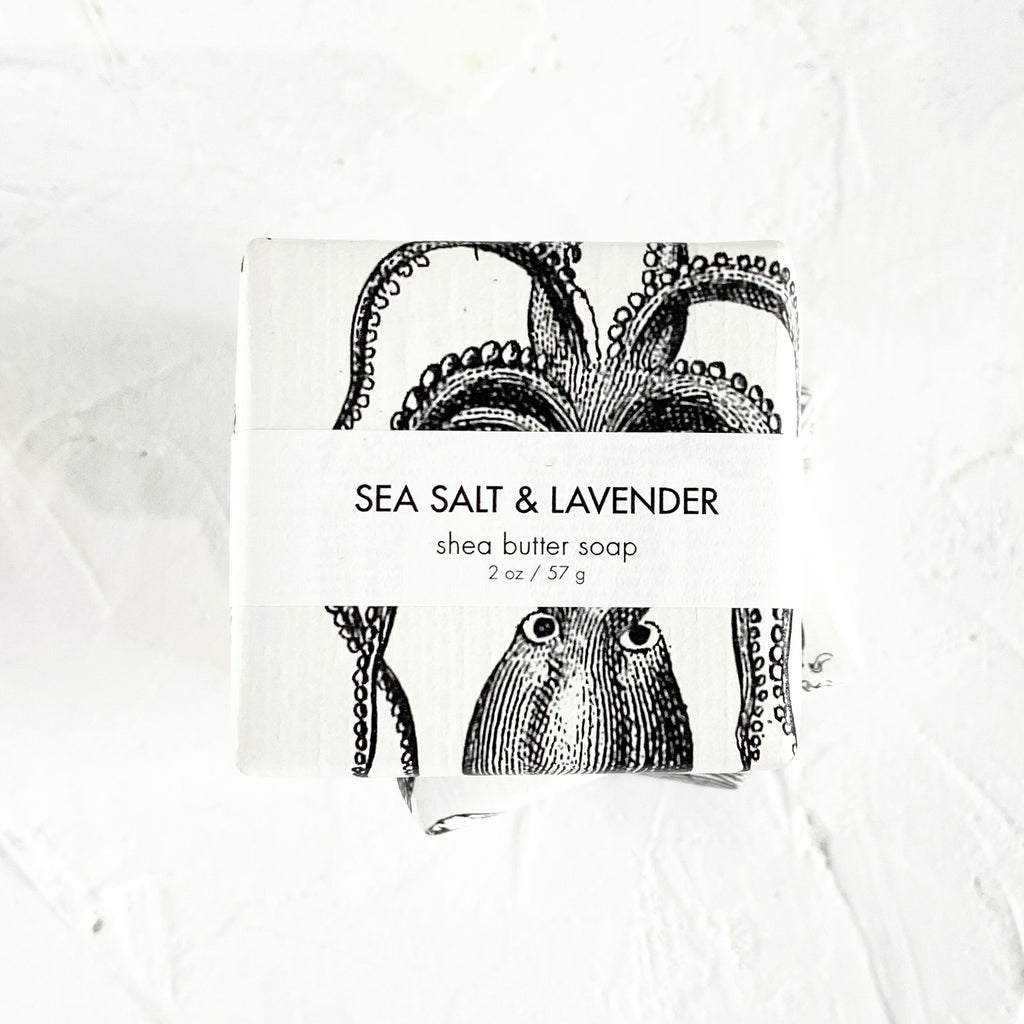 White square package with black text saying, “Sea Salt & Lavender Shea Butter Soap”. Image of an octopus.