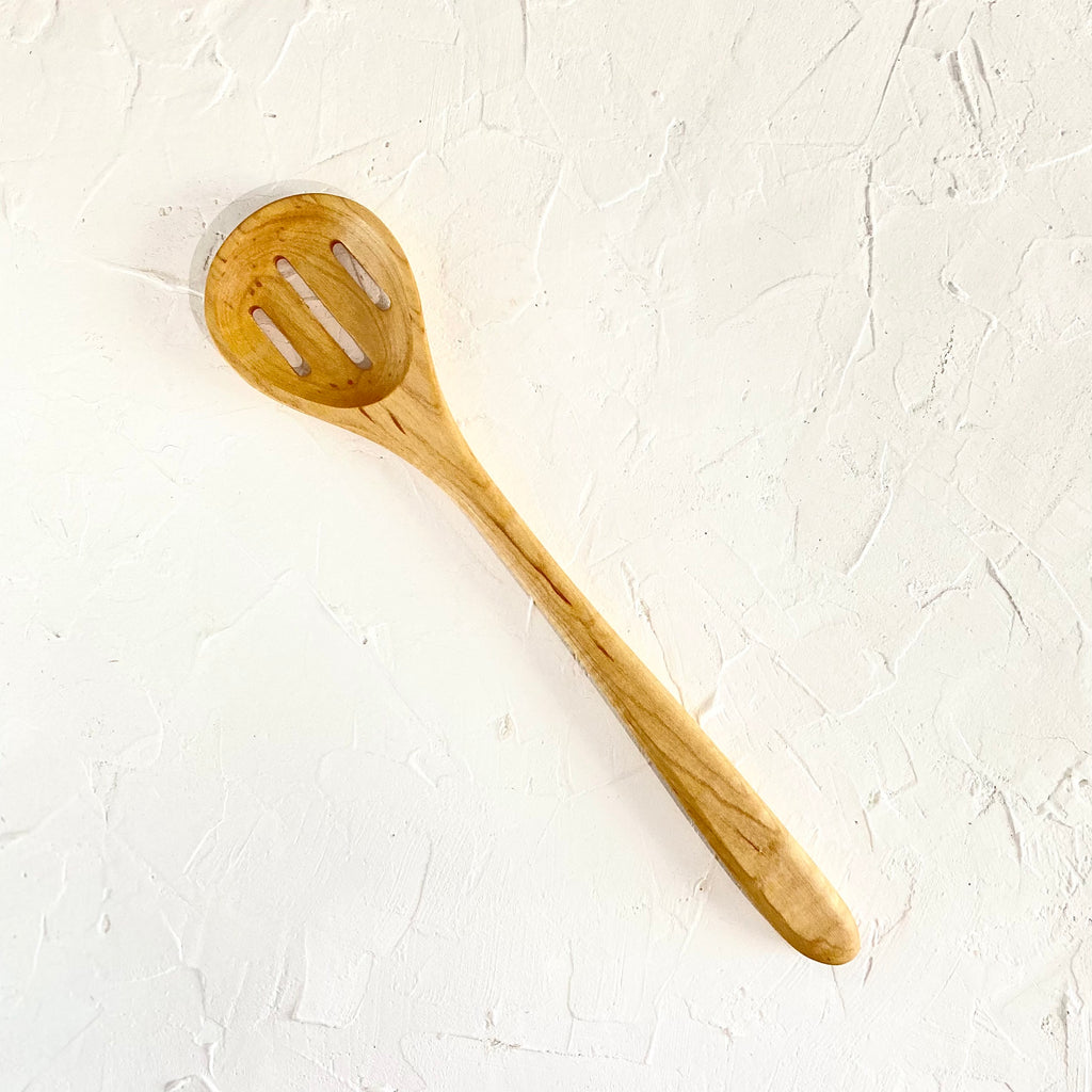 Hand carved wooden spoon with slots. 