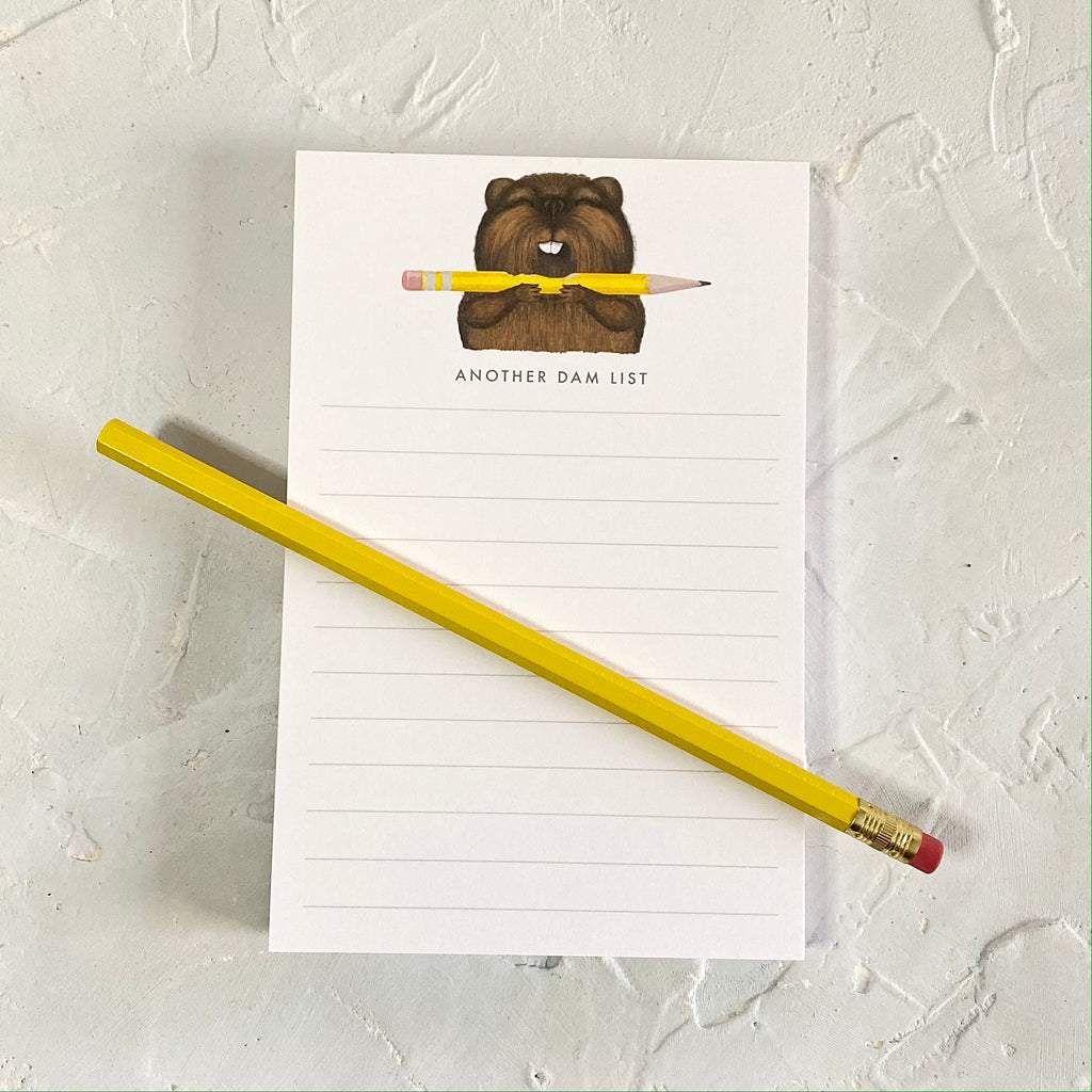 White notepad with image of a brown beaver holding a pencil in its teeth. Black text saying, 