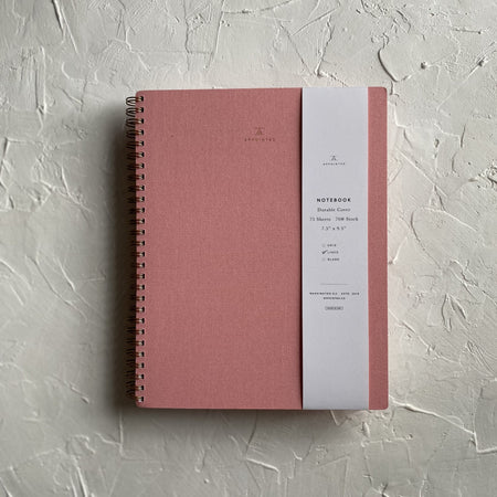 Blossom pink textured cover with brass spiral on left side.