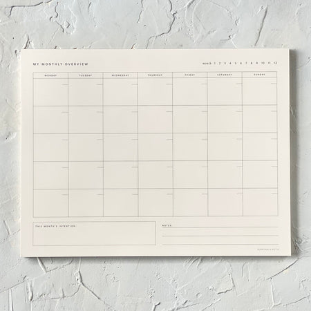 Rectangle ivory color pad with monthly grid to fill in.