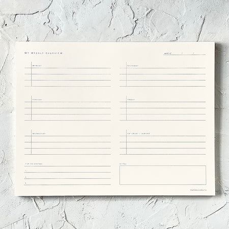 Rectangle ivory color notepad with weekly grid to fill in.