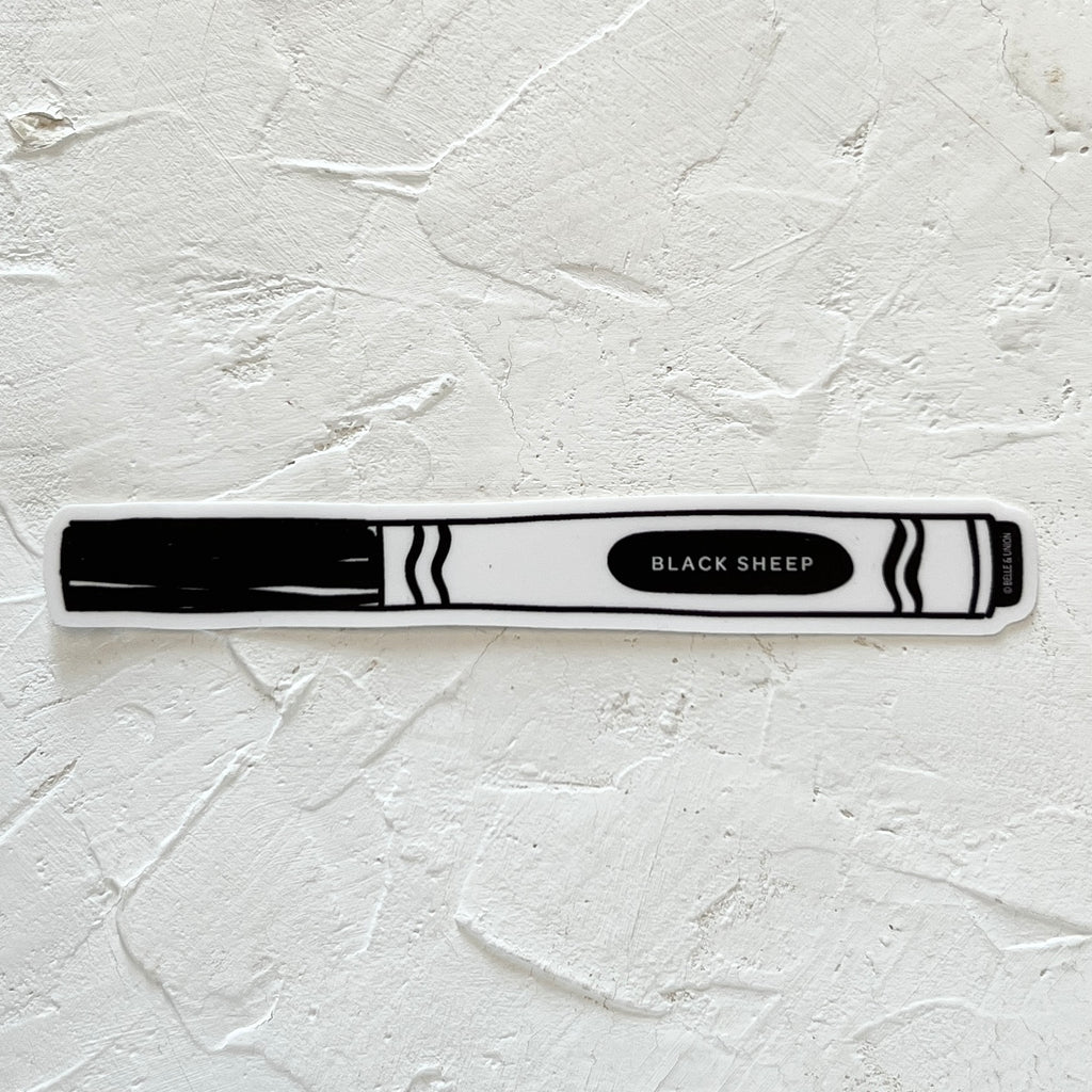 White sticker in the image of a black art marker with white text saying, “Black Sheep”. 