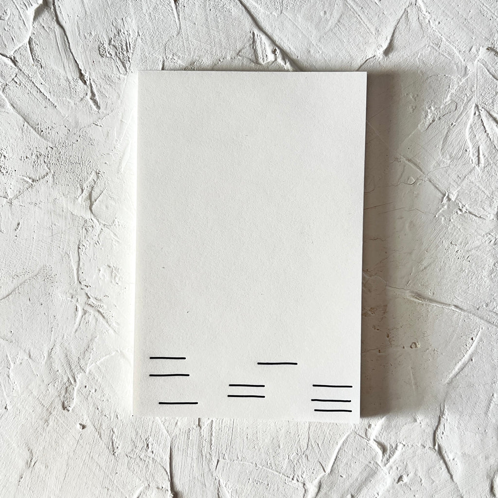 White notepad with black checkerboard lines across the bottom.