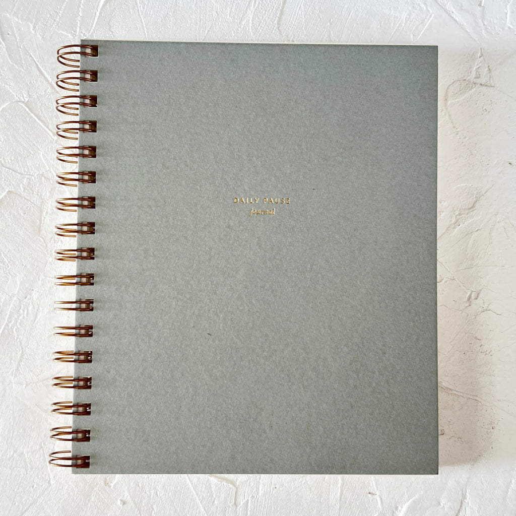 Sage green cover with gold foil text saying, "Daily Pause Journal". Gold coil binding on left side.