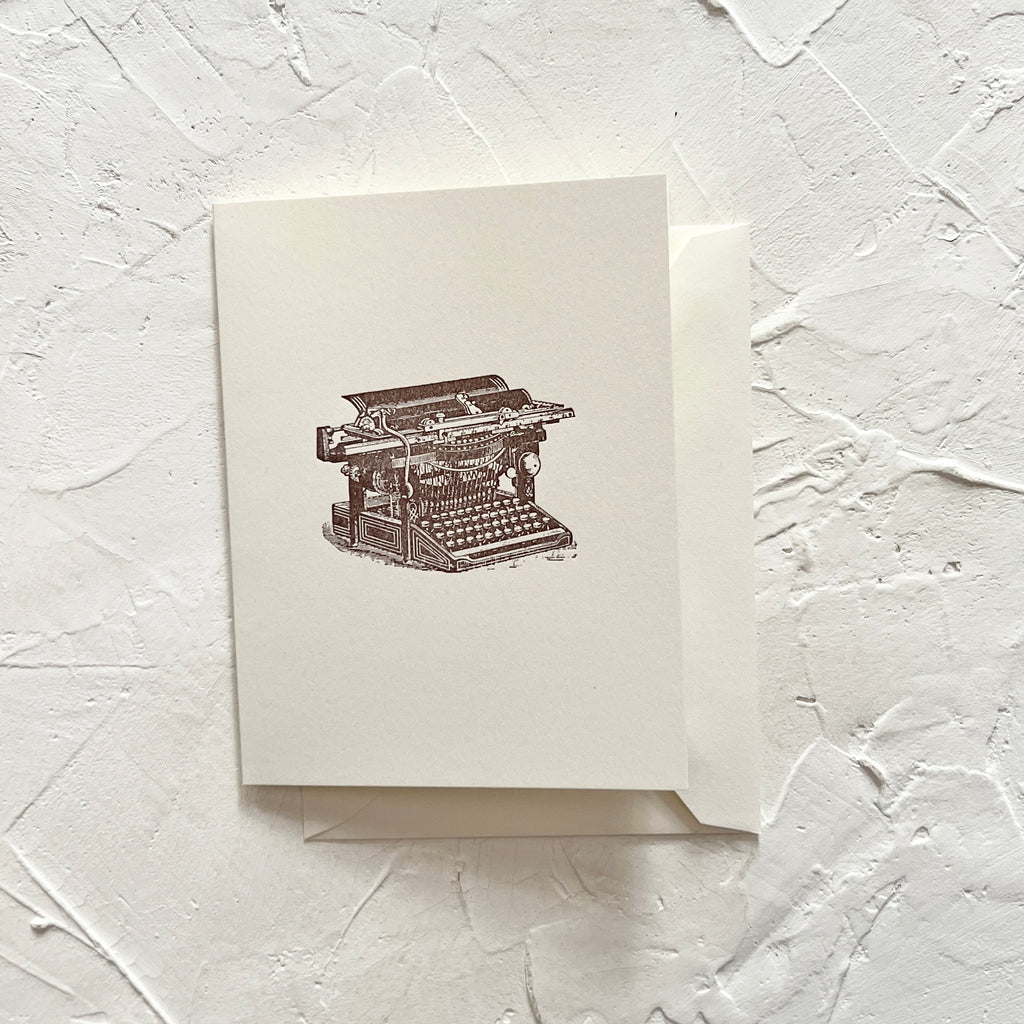 White card with an image of a vintage typewriter. A white envelope is included.