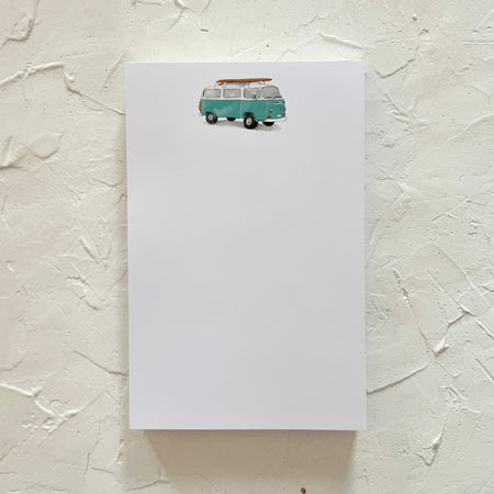 White notepad with a blue vintage van with a brown surfboard on roof.