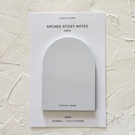 Arched shaped sticky notes in gray shades presented on a ivory background.