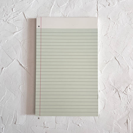 Mint green lined notebook paper notepad with white binding across the top. Image of small gold star in upper left corner.