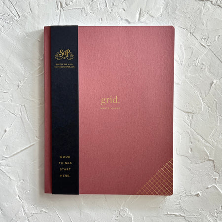 Blush pink cover with gold foil text saying, “Grid”.
