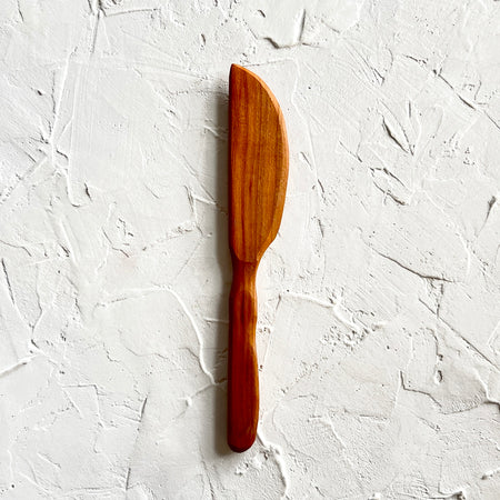 Wooden spatula carved to the right side.