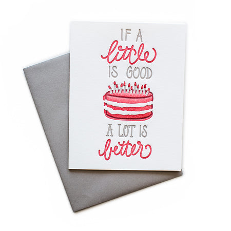 White card with gray and red text saying, “If A Little is Good A Lot is Better”. Image of a birthday cake with red and white frosting and candles. A gray envelope is included.