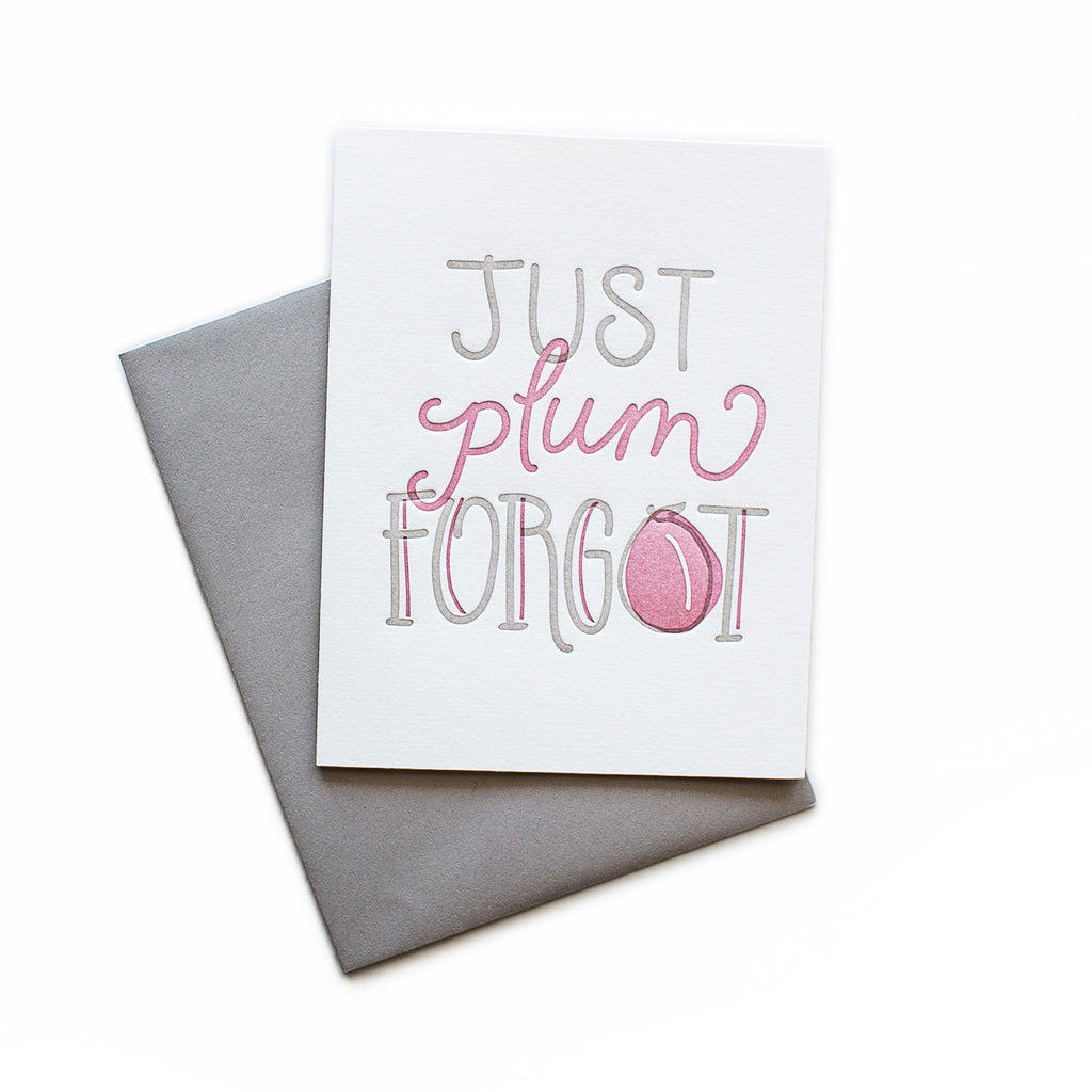 White card with gray and purple text saying, “Just Plumb Forgot”. Images of a plum fruit. A gray envelope is included.
