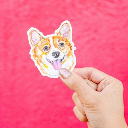 Sticker with an image of a corgi dog head with its tongue sticking out.