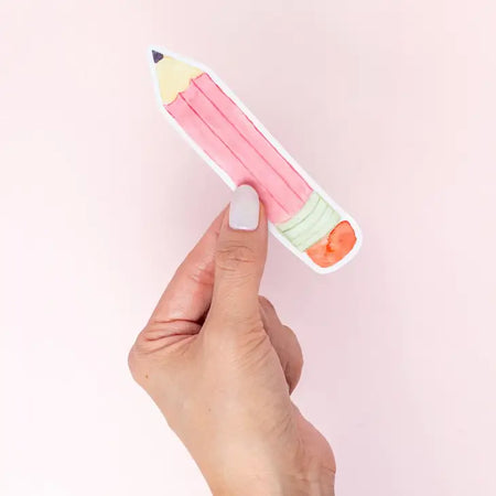 Sticker with an image of a pink pencil with a black tip, silver banding and pink eraser top.