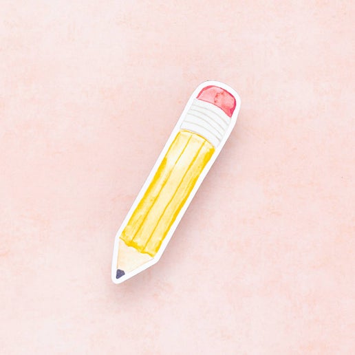 Sticker with an image of a yellow pencil with a black tip, silver banding and pink eraser top.