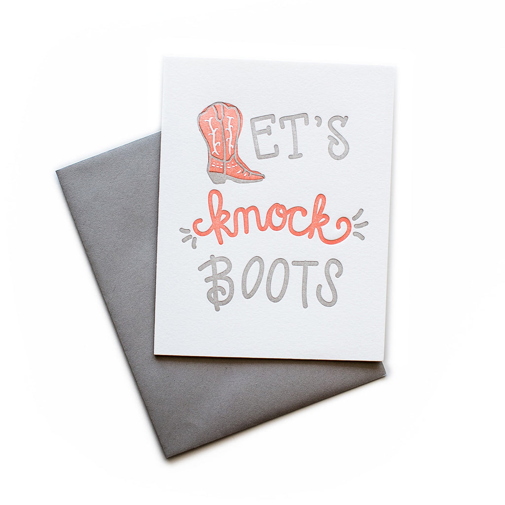 White card with gray and red text saying, “Let’s Knock Boots”. Image of a red cowboy boot. A gray envelope is included.