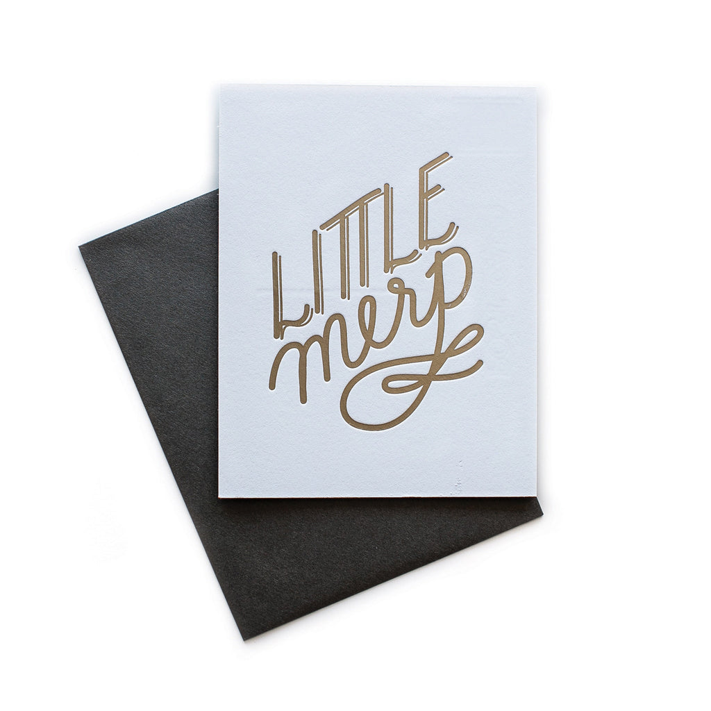 White card with gold text saying, “Little Merp”. A gray envelope is included.