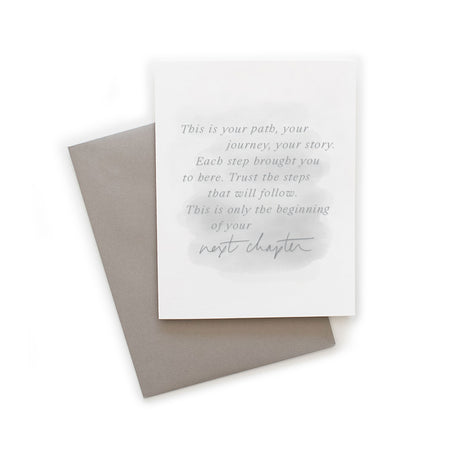 White card with gray muted brushstroke background with gray text saying, “This is your path, your journey, your story. Each step brought you to here. Trust the steps that will follow. This is only the beginning of your next chapter.” A gray envelope is included.