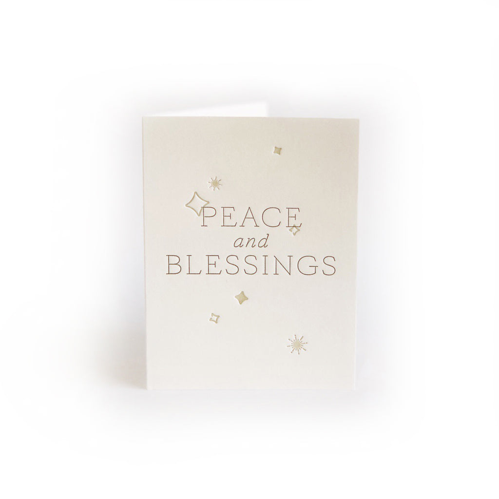 Ivory card with gray text saying, “Peace and Blessings”. Images of embossed stars and squares. A gray envelope is included.
