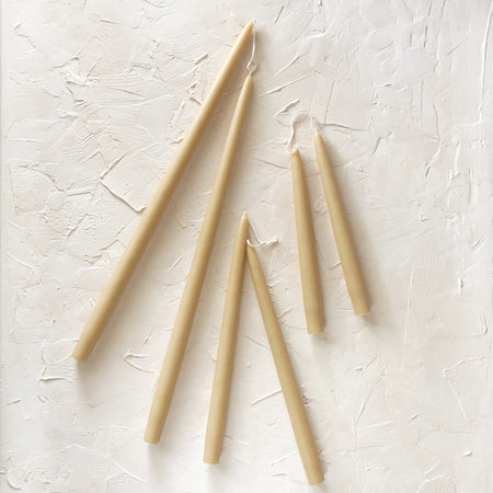 Tall skinny ivory colored tapered candles.