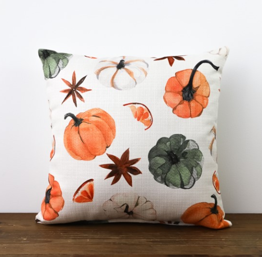 Square white pillow with images of orange pumpkins, green pumpkins and white pumpkins.