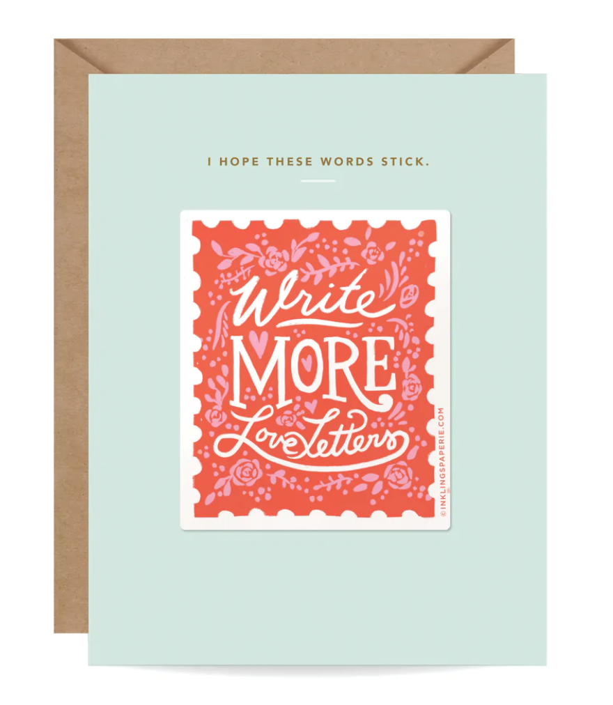Green card with gold foil and white text saying, “I Hope These Words Stick” and “Write More Love Letters”. Image of a red postage stamp with pink flowers scattered. A brown envelope is included.