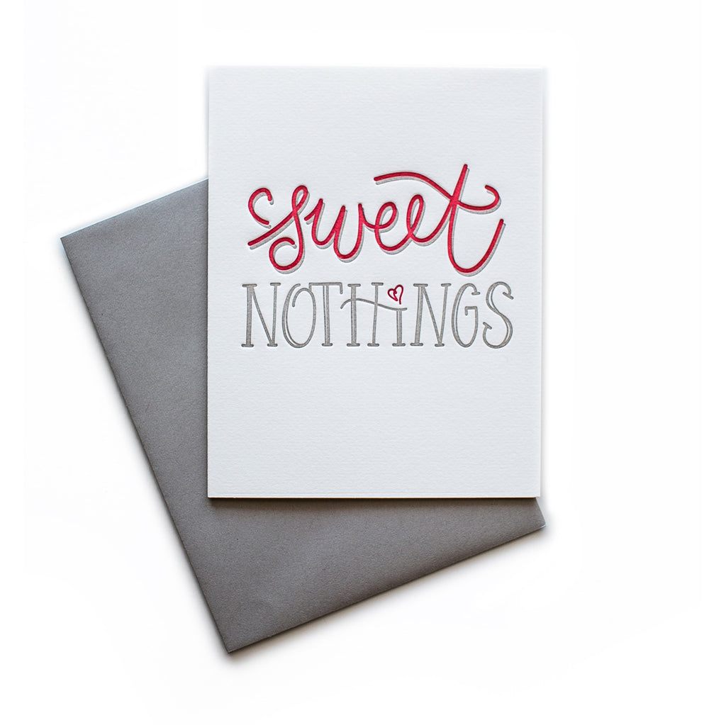 White card with gray and red text saying, “Sweet Nothings”. Images of a red heart. A gray envelope is included.