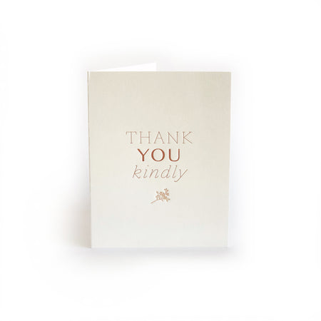 Ivory card with gold text saying, “Thank You Kindly”. Image of embossed flower sprig in center. A gray envelope is included.