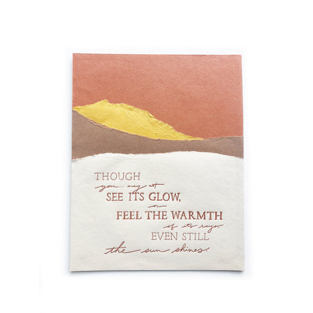 Art print with torn edge pieces of yellow, orange, brown and ivory paper in the image of mountains. Brown text saying, “Though You May Not See Its Glow, Feel the Warmth of Its Rays, Even Still the Sun Shines.” 