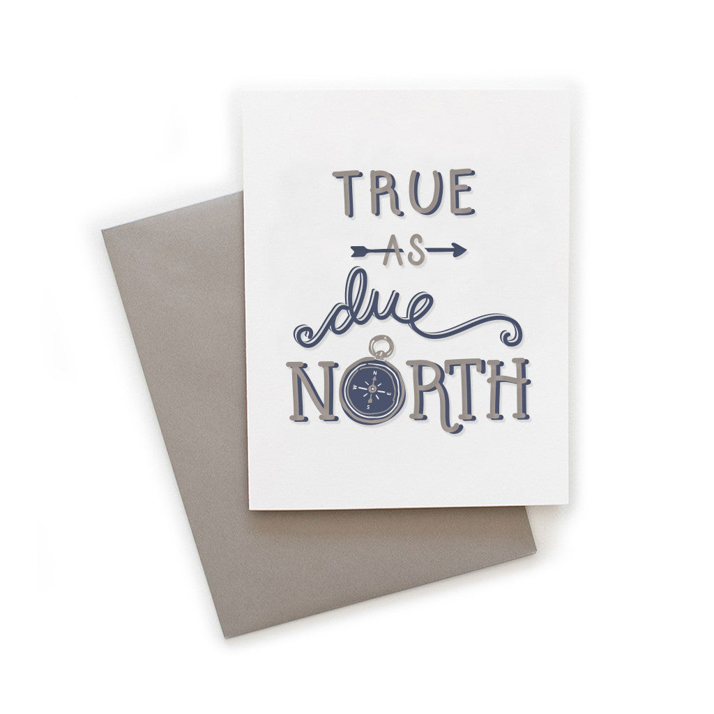 White card with gray and blue text saying, “True As Due North”. Images of a gray and blue compass. A gray envelope is included.