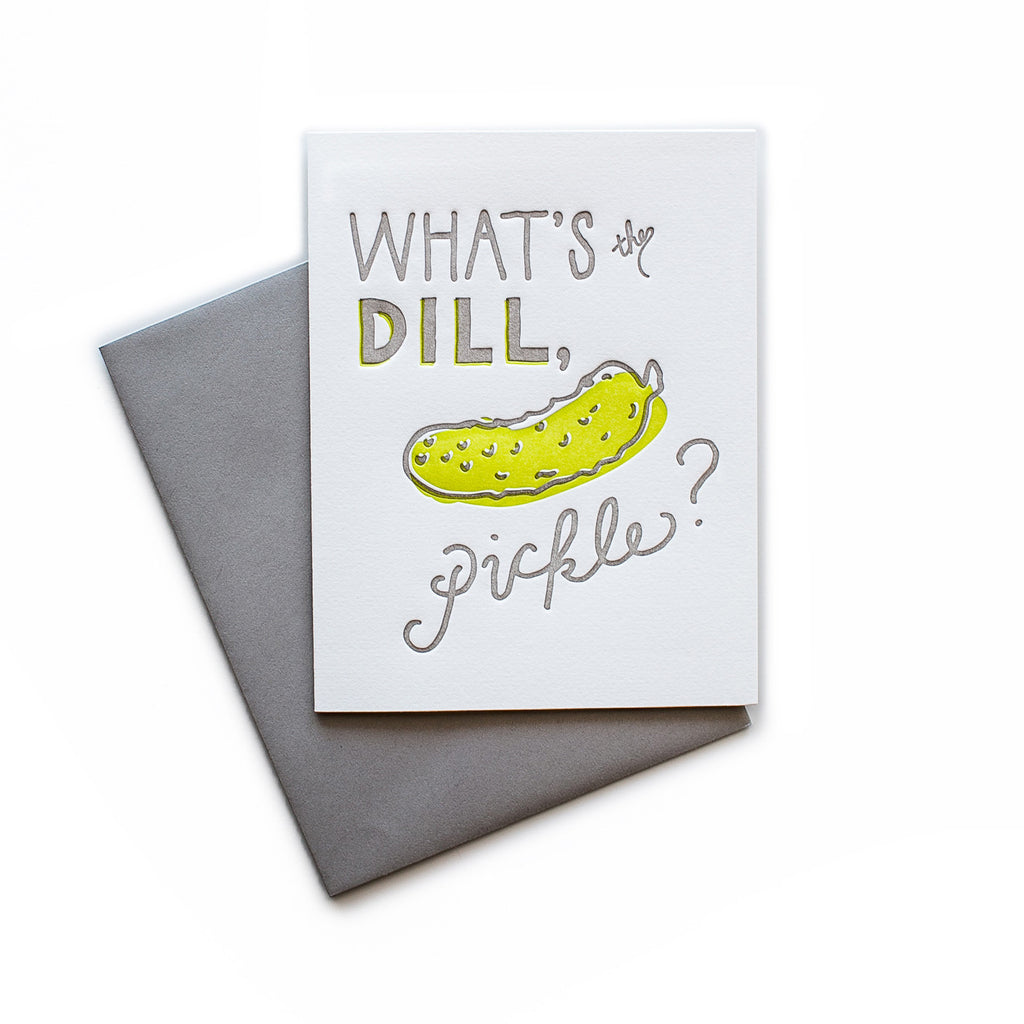 White card with gray and yellow text saying, “What the Dill, Pickle?” Image of a yellow dill pickle. A gray envelope is included.